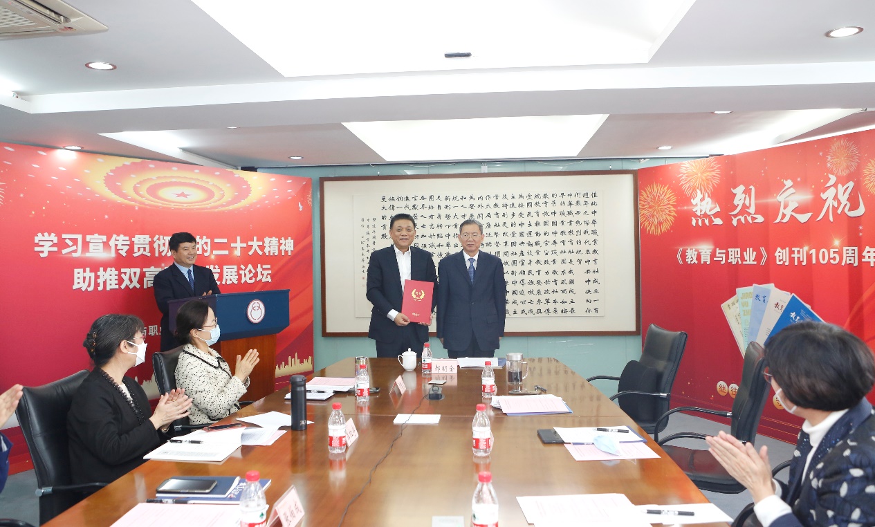 郝明金為《教育與職業(yè)》雜志編委代表陳曉明頒發(fā)聘書。中華職教社供圖