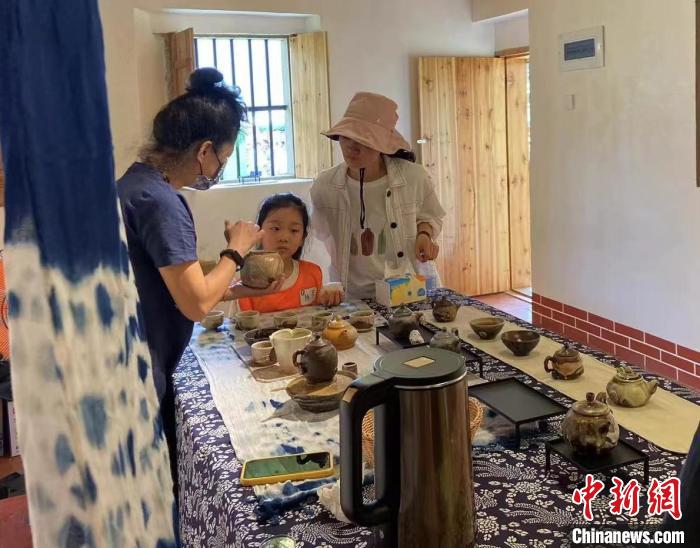 圖為：游客正在咨詢臺灣柴燒作品?！∪~秋云 攝