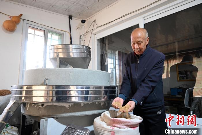 李家莊村民谷文朝重拾父輩的手藝，做起石磨面粉的營(yíng)生。　翟羽佳 攝