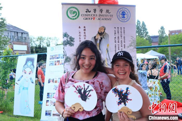 孩子們展示自己的吹墨畫團(tuán)扇作品。　魯汶孔子學(xué)院供圖