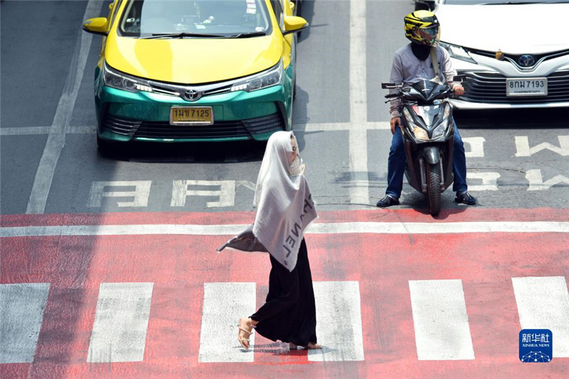 5月17日，行人在泰國曼谷街頭用圍巾遮陽。新華社發(fā)（拉亨攝）