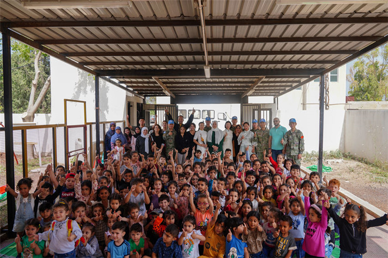 當?shù)貢r間5月30日，黎巴嫩南部庫雷拉公立小學(xué)，“六一”國際兒童節(jié)前夕，中國第21批赴黎維和多功能工兵分隊官兵看望慰問學(xué)校師生，并開展文化交流活動，圖為我維和官兵同師生合影。李竹林攝