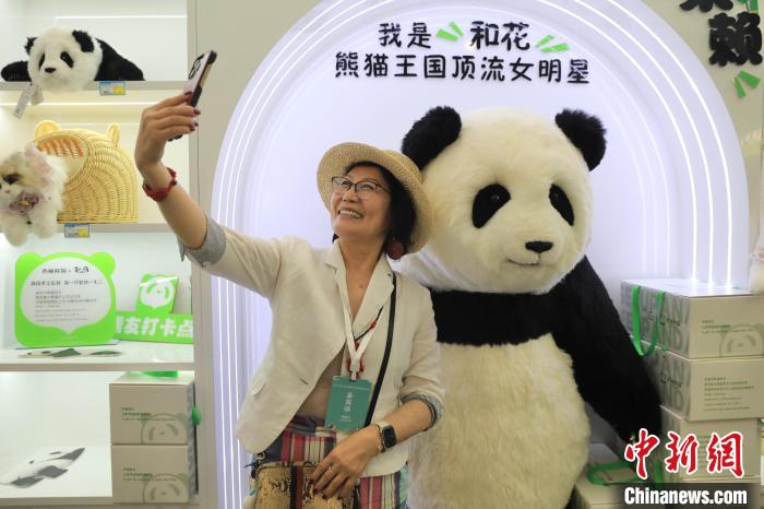 美國華視總裁楊蓮花與大熊貓文創(chuàng)產(chǎn)品合影?！⊥趵?攝