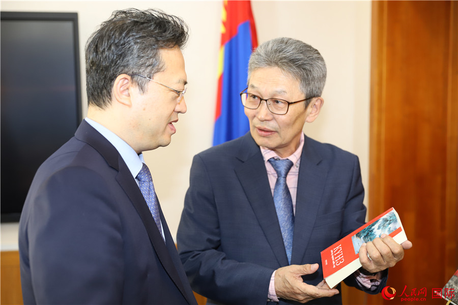 其米德策耶（右一）向李峙介紹翻譯成果。人民網(wǎng)記者 霍文攝