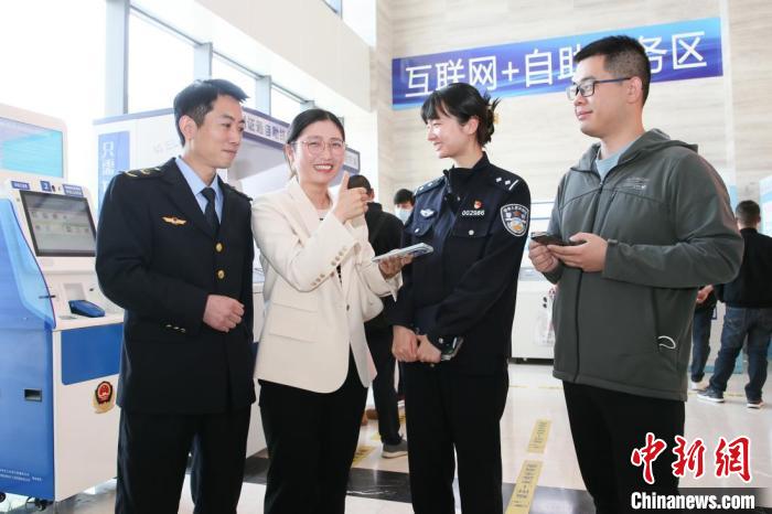 4月10日，安徽合肥，一家運輸企業(yè)負責人在工作人員的指導下，使用小程序辦理車管業(yè)務(wù)?！『戏示焦﹫D