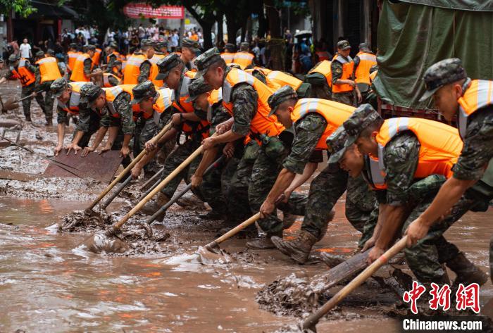 7月4日，萬(wàn)州區(qū)五橋街道，武警官兵清理街道上的淤泥?！∪矫宪?攝