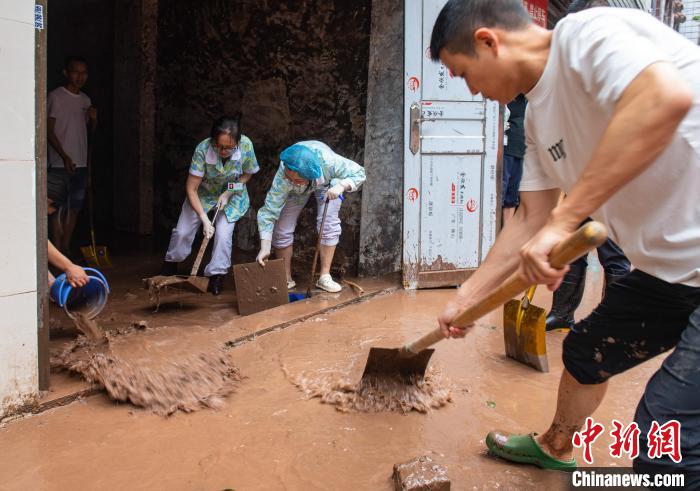 7月4日，萬(wàn)州區(qū)五橋街道，洪水退去后，居民開(kāi)展清淤工作。　冉孟軍 攝