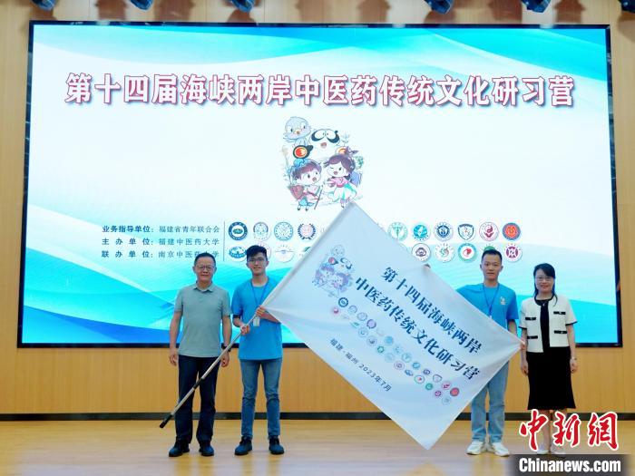 共青團(tuán)福建省委副書記吳雪(右一)、福建中醫(yī)藥大學(xué)黨委副書記林羽(左一)為兩岸學(xué)生代表頒授營旗?！≡S燁婷 攝