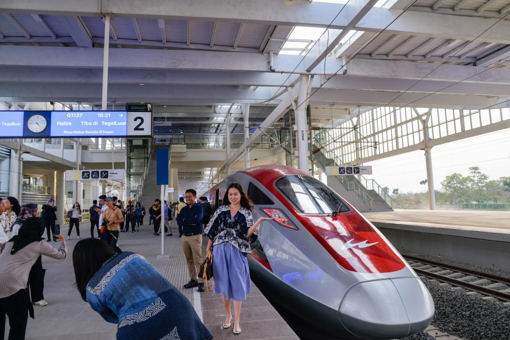 10月17日，在印度尼西亞萬隆德卡魯爾站，乘客在站臺上和雅萬高鐵高速動車組列車合影。