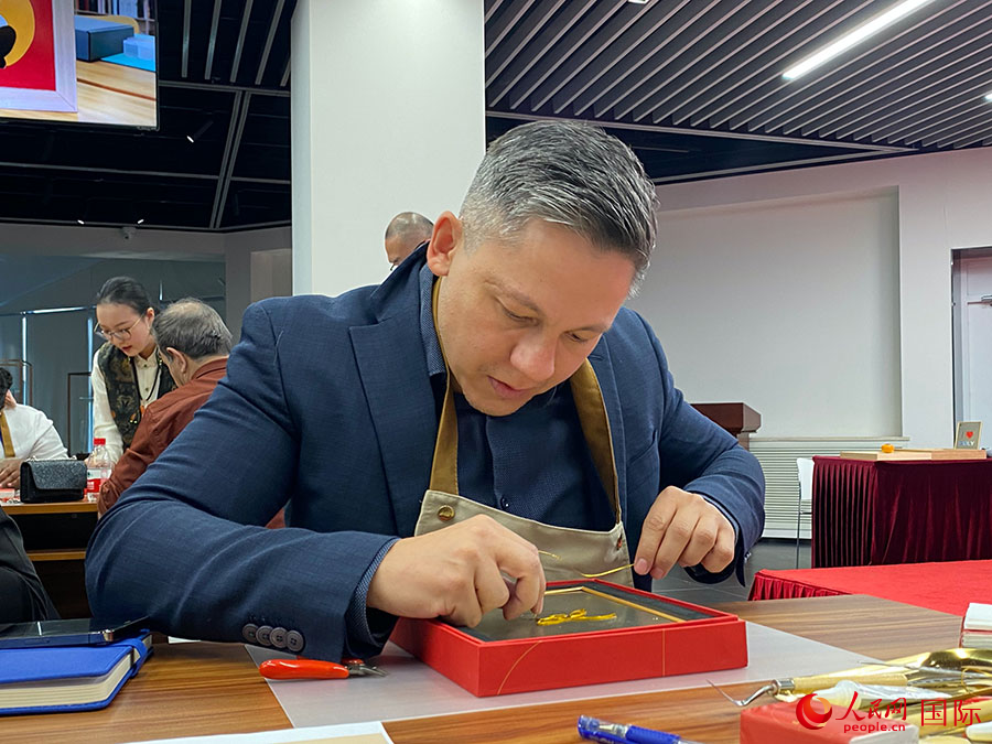 2023“一帶一路”媒體合作論壇聯(lián)合采訪團團員，親身體驗景泰藍(lán)工藝。人民網(wǎng)記者 于洋攝