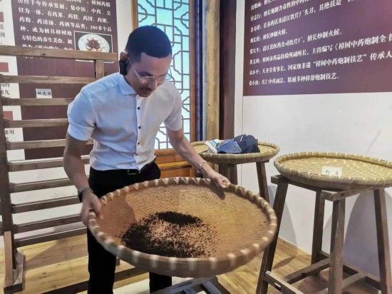 2023“一帶一路”媒體合作論壇聯(lián)合采訪團(tuán)團(tuán)員在非遺文化展示館體驗(yàn)中藥炮制技藝。（本報(bào)記者 黃超攝）