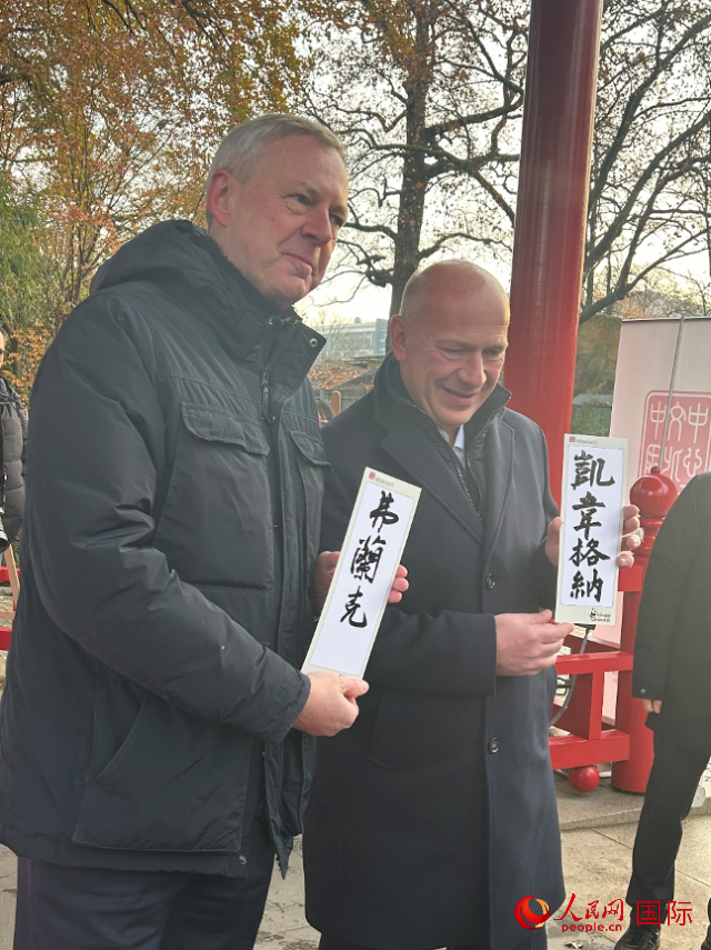 柏林市長韋格納（右）、動物園監(jiān)事會主席布魯克曼（左）手持中國文化中心工作人員現(xiàn)場手書的中文名字。人民網(wǎng)記者 徐馨攝