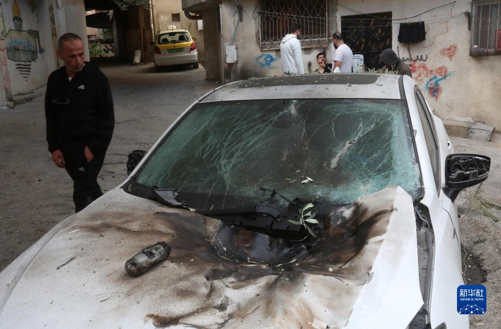 12月17日，在約旦河西岸城市圖勒凱爾姆附近的一處難民營，人們查看在沖突中損毀的車輛。新華社發(fā)（尼達(dá)爾·艾仕塔耶?dāng)z）