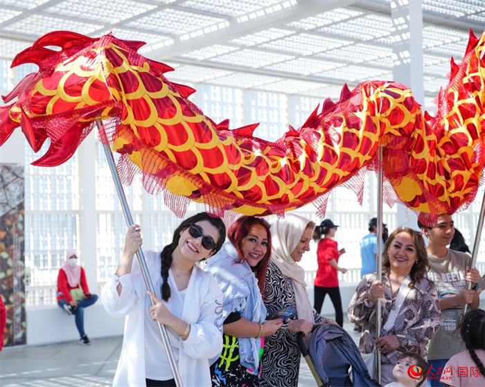 游客體驗(yàn)舞龍。 人民網(wǎng) 塔里克·易卜拉欣攝