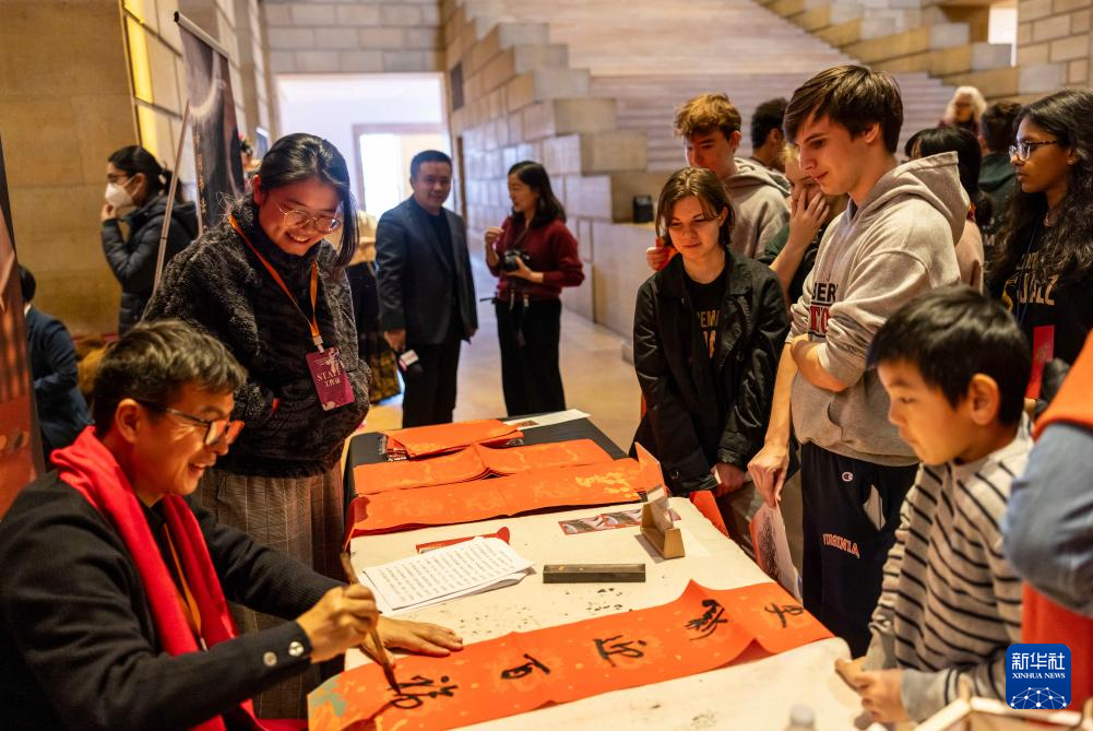 2月11日，書法家在美國費城藝術(shù)博物館舉行的龍年迎新春活動上為參觀者書寫對聯(lián)。新華社發(fā)（周煥新攝）