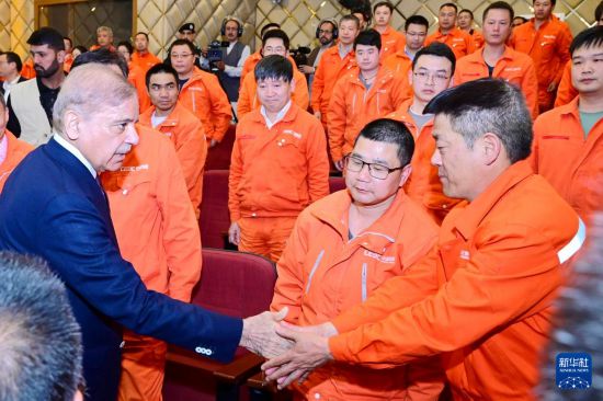 4月1日，在巴基斯坦西北部開伯爾-普什圖省達蘇，巴基斯坦總理夏巴茲（左）同達蘇水電站項目中方員工握手。新華社發(fā)（巴基斯坦新聞與廣播部下轄媒體信息部門供圖）