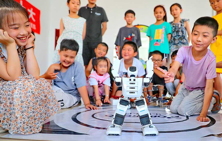 2022年7月19日，河北省秦皇島市海港區(qū)白塔嶺街道秦皇半島第二社區(qū)內(nèi)，小朋友正在觀看“機(jī)器人跳舞”。 曹建雄攝