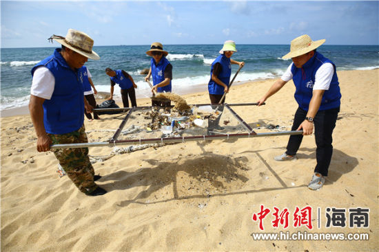 環(huán)保志愿者用篩網(wǎng)“淘”出海灘上的垃圾。