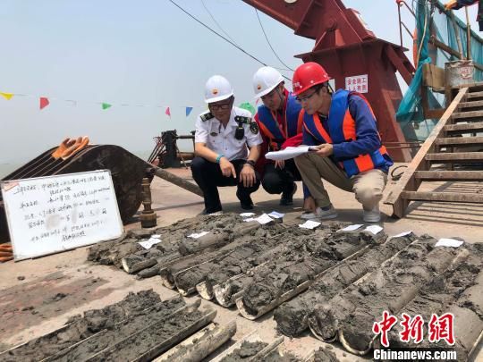 圖為勘察設(shè)計(jì)人員與海事局工作人員查看巖芯情況?！∥赫?攝