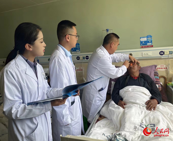 董光明（左三）帶領(lǐng)醫(yī)生對(duì)患者進(jìn)行術(shù)前檢查。人民網(wǎng)記者 杜燕飛攝