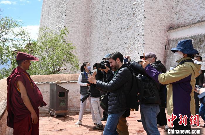 圖為中外媒體拍攝朝拜布達(dá)拉宮的僧人?！≮w朗 攝