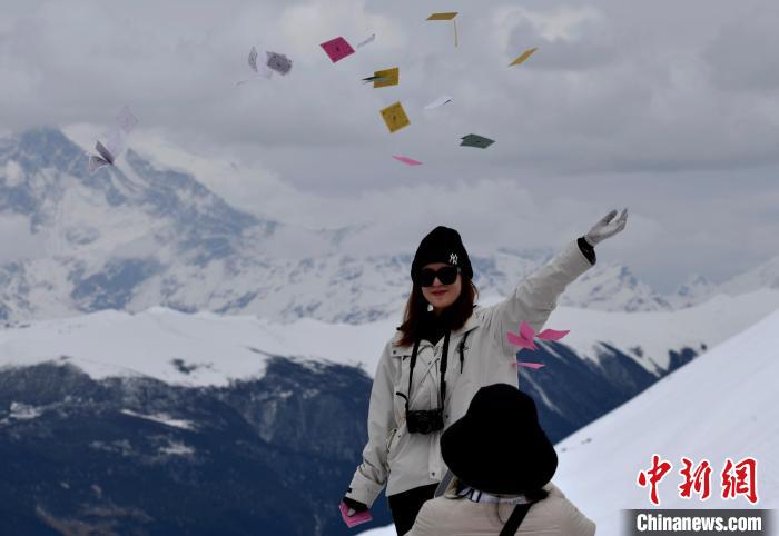 圖為5月14日，游客在西藏林芝色季拉山觀景臺拋灑“隆達”(風馬旗，藏族民眾的一種祈福方式)?！±盍?攝