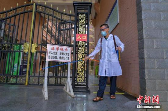 資料圖：?？诮?jīng)濟學(xué)院的工作人員在學(xué)生宿舍樓入口消毒。 中新社記者 駱云飛 攝