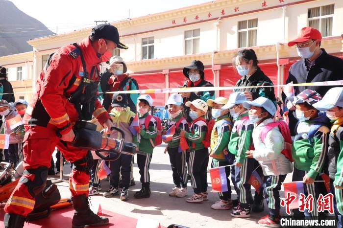 圖為消防指戰(zhàn)員為學(xué)生講解、演示先進(jìn)救援裝備?！≮w琳 攝