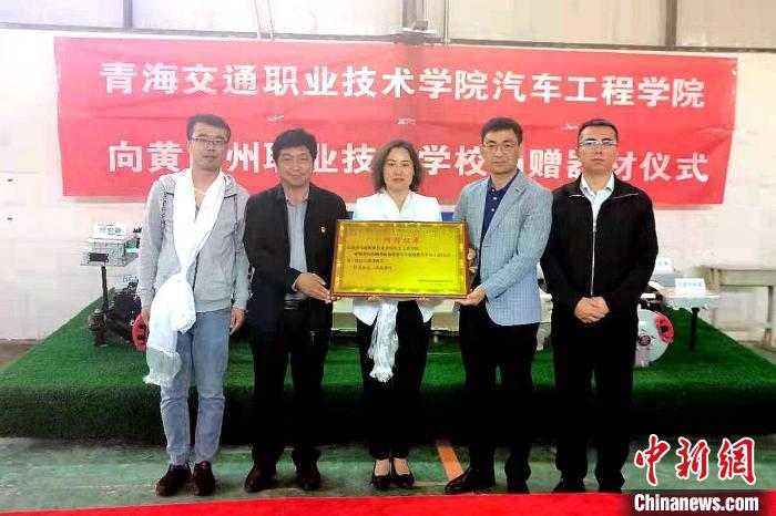 圖為李富香(中)代表學(xué)校為州縣技校捐贈器材。(資料圖) 青海省教育廳供圖