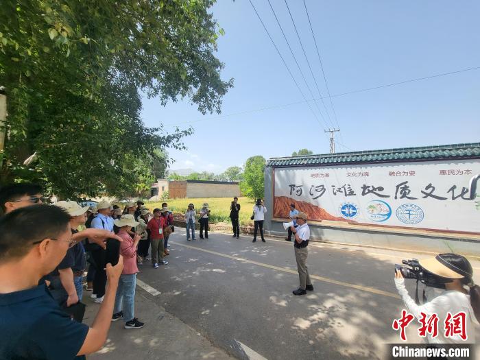 圖為中國地質(zhì)大學(北京)教授張緒教介紹村落情況?！『衍?攝