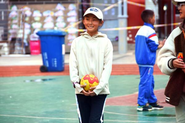 在高原上教孩子們打手球，“慢慢兒來(lái)，甭著急！”