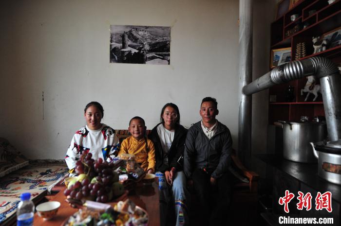 圖為8月12日，2018年7月從距那曲市色尼區(qū)城區(qū)那曲鎮(zhèn)90千米外的古露鎮(zhèn)當桑村搬遷至城區(qū)的旦增(右一)與家人在80多平方米的新家合影(資料圖)?！垈?攝
