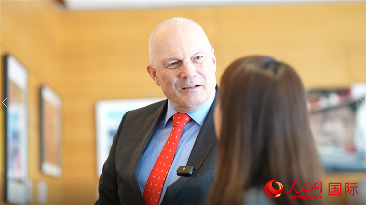 瑞士駐華大使白瑞誼介紹使館內(nèi)陳列的照片。人民網(wǎng) 彭昱凱攝