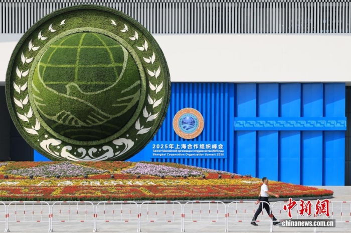 8月31日，天津，一名工作人員從2025年上海合作組織峰會(huì)主會(huì)場(chǎng)外的景觀花壇旁經(jīng)過。當(dāng)日，2025年上海合作組織峰會(huì)在天津舉行。<a target='_blank' href='/'><p  align=