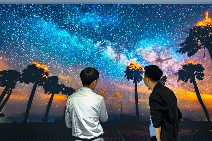 長春光博會希達電子展區(qū)，一位工作人員正在給一位觀眾講解。（長春新區(qū)供圖）