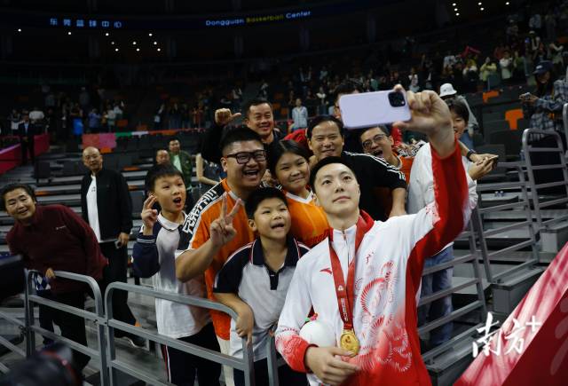 11月12日，十五運(yùn)會(huì)男籃成年組決賽，廣東隊(duì)獲得冠軍后，胡明軒與球迷們合影留念。張由瓊 攝