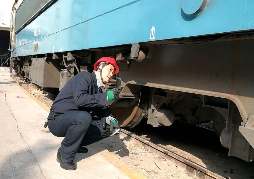 韓文盛全神貫注檢查機(jī)車走行部。