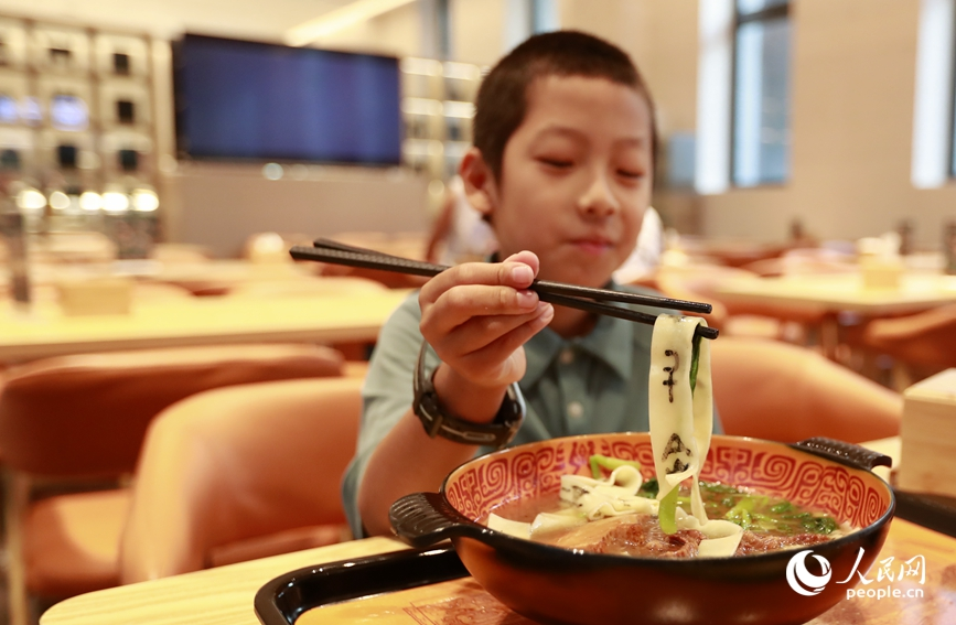殷墟博物館推出的甲骨文面深受游客喜愛。人民網(wǎng)記者 慎志遠(yuǎn) 攝