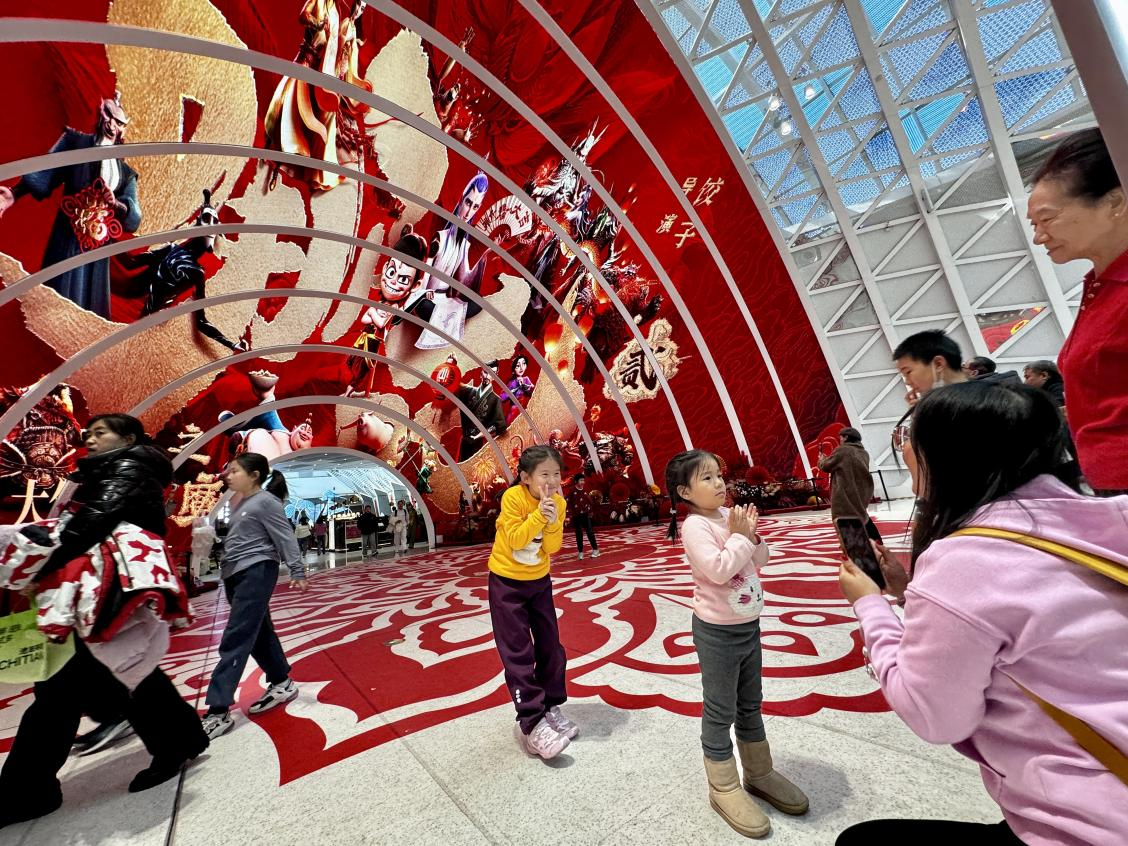 乙巳蛇年春節(jié)期間，影迷在《哪吒之魔童鬧?！肪薹?bào)前拍照打卡。