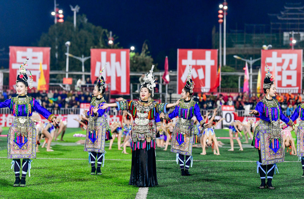 2025年3月14日，2025年貴州“村超”40強交叉賽在榕江“村超”足球場舉行，演員在比賽間隙表演侗族大歌，民族文化伴隨著體育賽事成功“出圈”。圖片來源：新華社