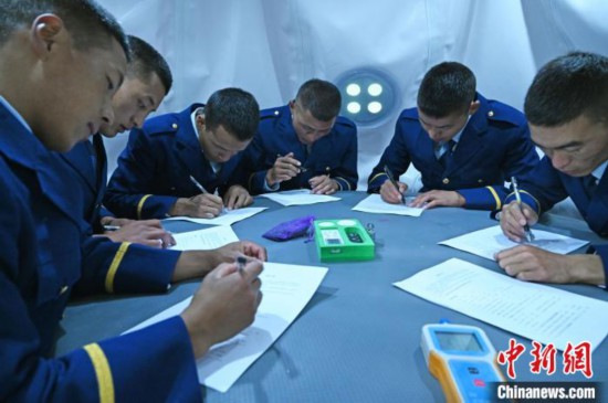 圖為消防員在高壓氧艙內(nèi)填寫問卷?！≮w朗 攝