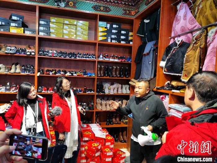 圖為中外媒體在玉樹州玉樹市甘達(dá)村采訪?！?zhí)砀?攝