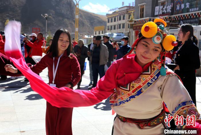 圖為中外記者向當(dāng)?shù)孛癖妼W(xué)習(xí)民族歌舞文化?！?zhí)砀?攝