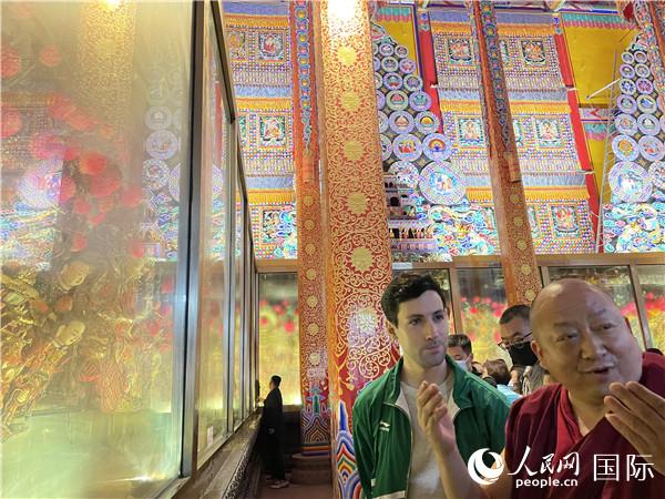 7月25日，省級非物質(zhì)文化遺產(chǎn)項目塔爾寺酥油花的代表性傳承人朋措堅參（右）在塔爾寺酥油花館講解酥油花的制作過程。人民網(wǎng) 謝瑩攝