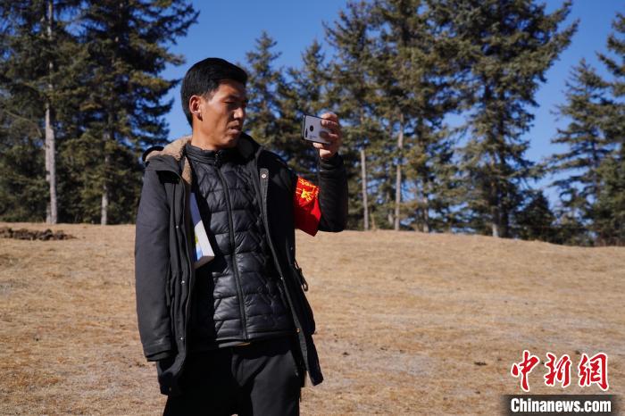 圖為桑杰加進行巡查并拍照記錄。　馬銘言 攝