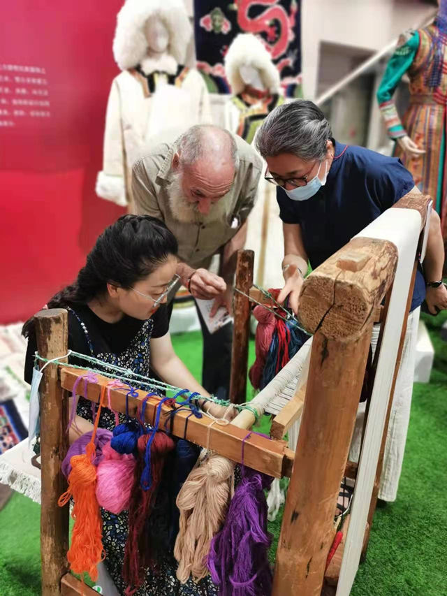 楊永良的學(xué)生在展會上向客商介紹加牙藏毯編織技藝。受訪者供圖