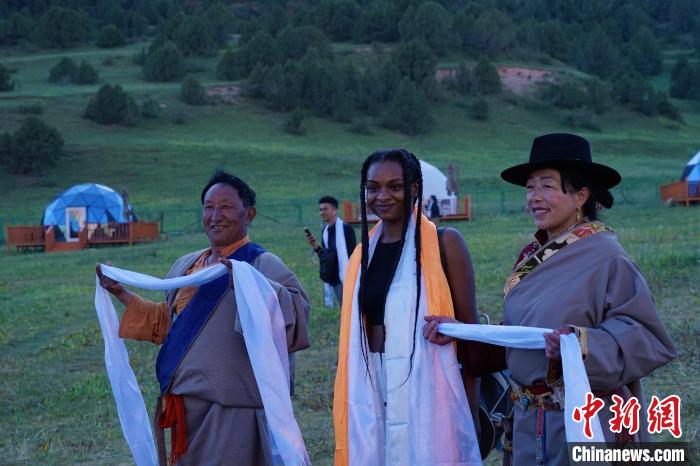 圖為當?shù)孛癖娕c外籍留學生合影留念?！●R銘言 攝