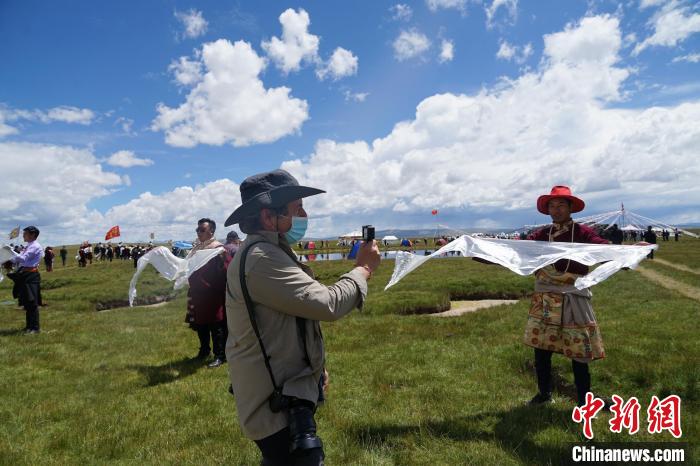 圖為一名外籍?dāng)z影師記錄當(dāng)?shù)夭刈鍤g迎儀式?！●R銘言 攝