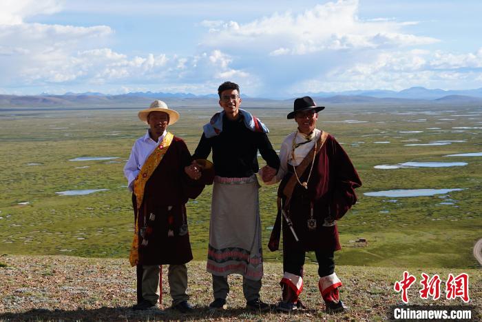 圖為一名留學(xué)生身穿自己國(guó)家的服飾和藏族民眾合影留念?！●R銘言 攝