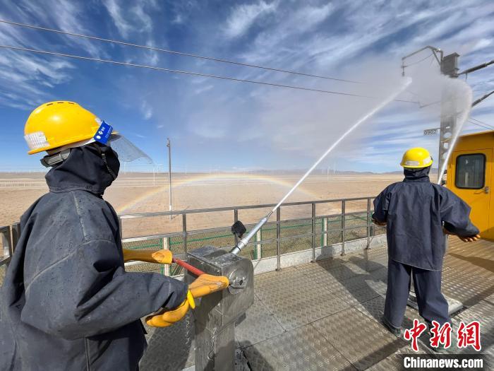 圖為水炮手操作高壓水槍對(duì)絕緣子進(jìn)行清洗。　高啟宏 攝